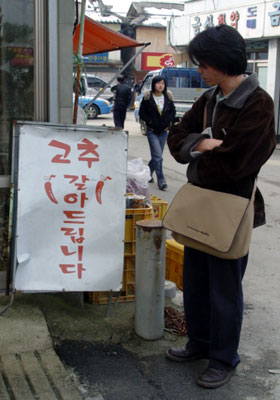 '고추를 갈아드립니다'라는 촌철살인적 문구에 감복해 사색에 잠겨 있는 김모 작가